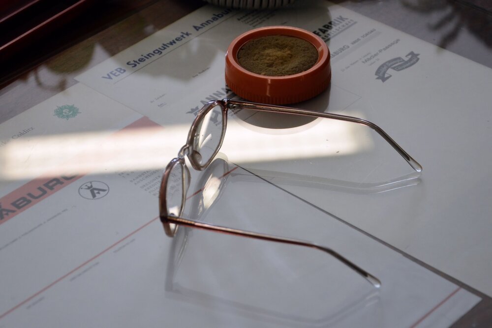 Ausgleich beruflicher Benachteiligungen (Symbolbild Brille liegt auf Unterlagen von Arbeitgebern)