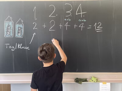 Kind der gruuna Schule rechnet den Verbrauch an Milchkartons aus