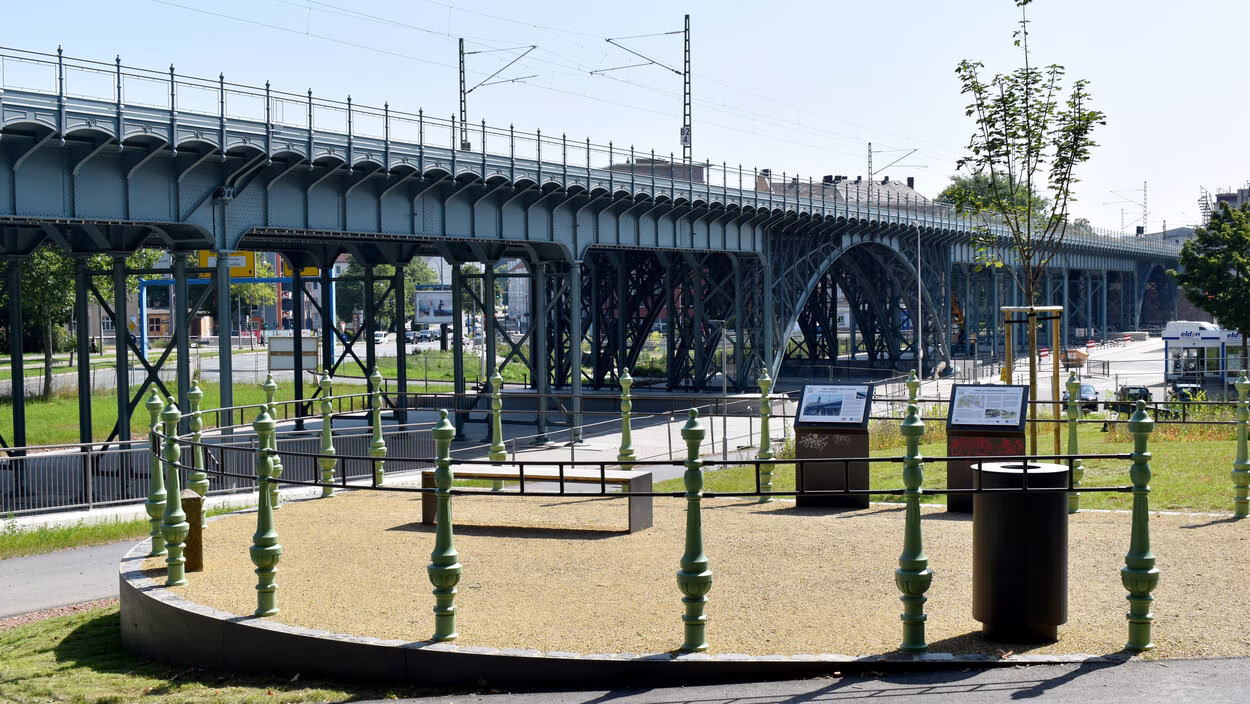 Der erhöhte Aussichtspunkt „Balkon“ im Norden des Areals bietet einen freien Blick auf das Eisenbahnviadukt, eingefasst von historischen Geländerpfosten des alten Bauwerks.