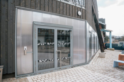 Außenansicht der Stadtwirtschaft/Kiezkantine mit Holz- und Metallverkleidung.