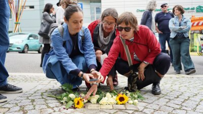 Angehörige von Irmgard Goeritz legen Blumen auf den Stolpersteinen nieder
