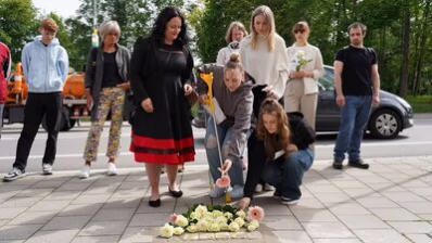 Teilnehmende der Stolpersteinverlegung legen Rosen nieder