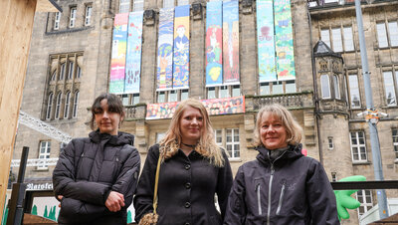 Talia Groß (Schülerin 6. Klasse), Camille Sasse (Lehrerin), Katharina-Kästel Sasse (Lehrerin) von der Montessori-Schule mit den diesjährigen Friedensbannern am Rathaus