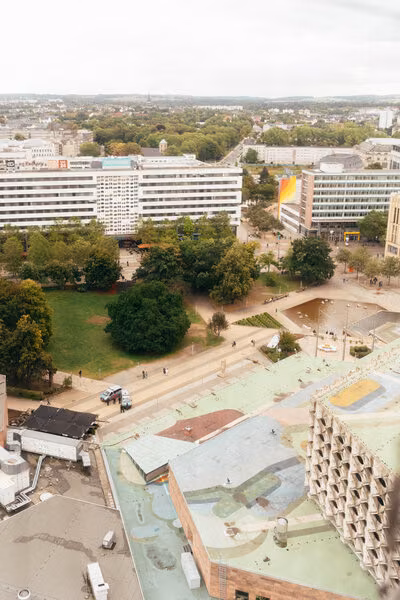 Ausblick vom Congresshotel Chemnitz auf die Stadthalle mit buntem Dachkunstwerk.