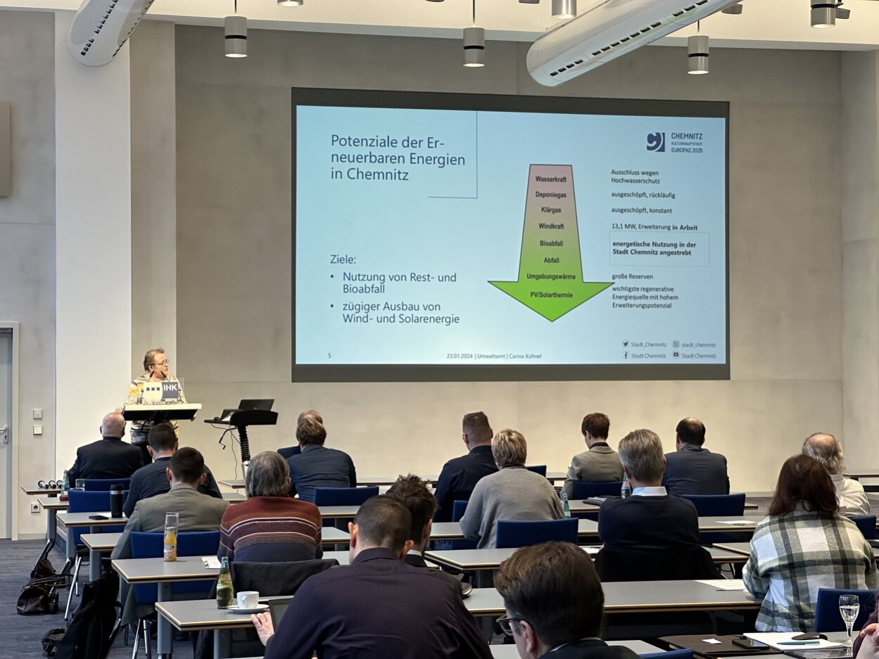 Die Leiterin des Umweltamtes der Stadt Chemnitz, Carina Kühnel, hält vor zahlreichen Teilnehmer:innen ihren Vortrag zum Thema THG-Emissionen Chemnitz