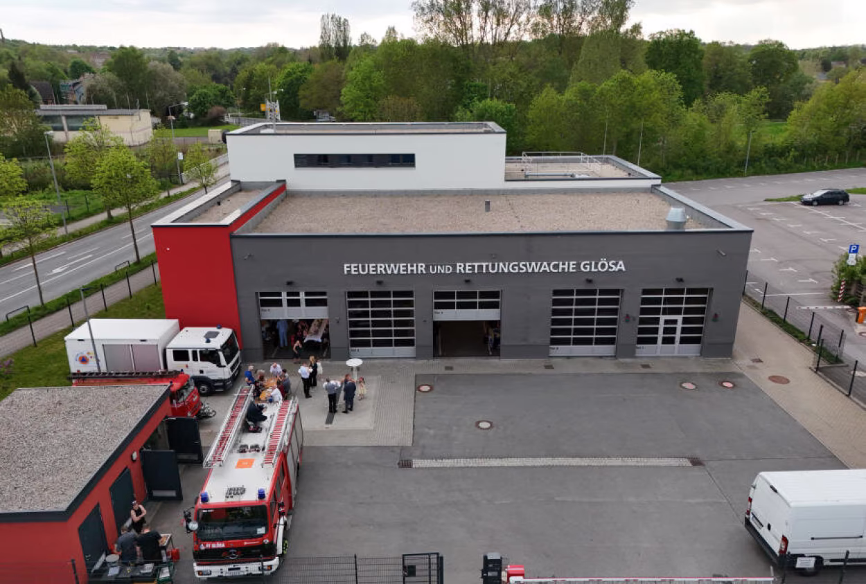 Das Ger&auml;tehaus der Freiwilligen Feuerwehr ist dunkelgrau und hat f&uuml;nf Einfahrten f&uuml;r Feuerwehrfahrzeuge. Im Vordergrund auf der linken Seite ist ein rotes Nebengeb&auml;ude zu sehen.
