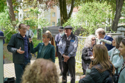Ein Angehöriger hält eine Rede und richtet seinen Blick zu den Besucherinnen und Besuchern.