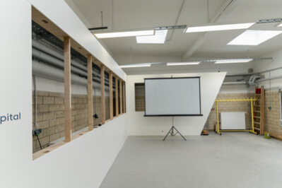 Blick in einen Workshopraum der Stadtwirtschaft mit Leinwand.