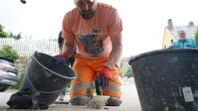 Ein Mitarbeiter des Chemnitzer Bauhofes verlegt den Stolperstein für Rudolf Dähnert