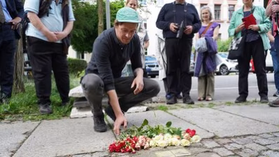Teilnehmende der Stolpersteinverlegung legen Blumen nieder
