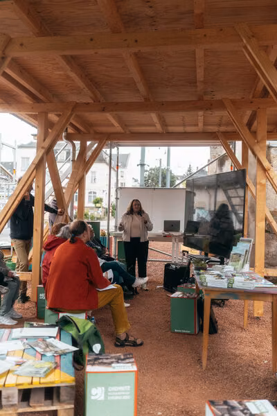 Workshop am Garagencampus Chemnitz unter offener Holzüberdachung mit großem Screen.