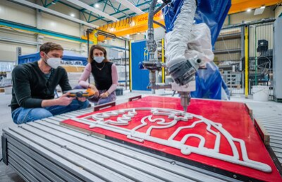 Prof. Dr. Sandra Gelbrich und Enrico Rudolph überwachen den 3D-Druck des Schwibbogens.