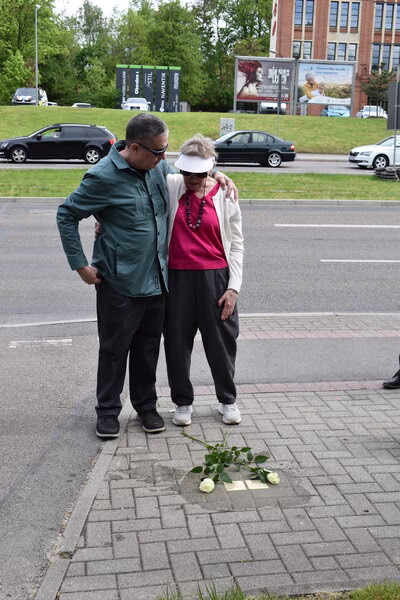 Sonia Ascher und ihr Mann stehen an den Stolpersteinen ihrer Eltern.