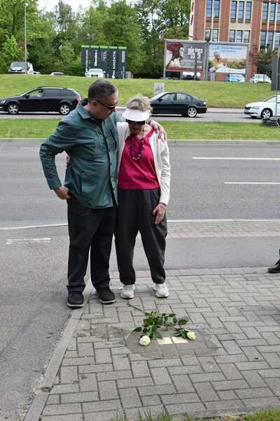 Sonia Ascher und ihr Mann stehen an den Stolpersteinen ihrer Eltern.