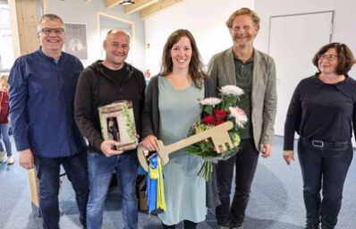 Offizielle Gäste der Eröffnung stehen im Raum des erweiterten Jugendclubs Einsiedel und halten den symbolischen Schlüssel.