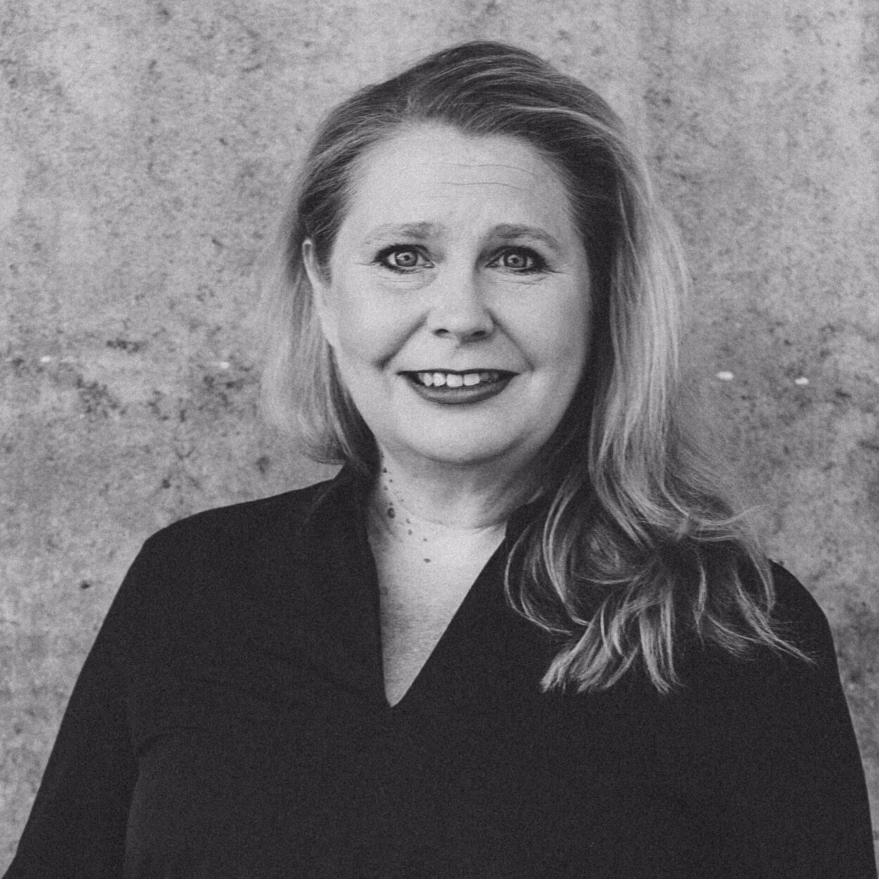 Suvi Innilä is smiling friendly in the black and white picture. She has long, light-coloured hair.