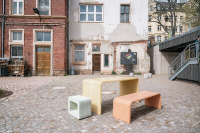 Sitzgruppe aus modernen Betonelementen im Innenhof der Stadtwirtschaft.