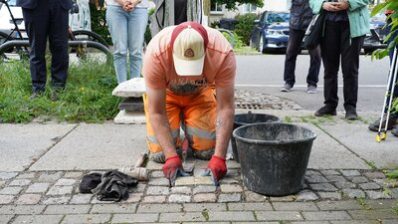 Ein Mitarbeiter des Chemnitzer Bauhofs verlegt die Stolpersteine für Familie Hoff