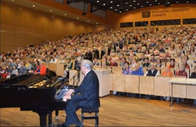 Prof. Dr. Roland Schöne bei einer früheren Vorlesung am Klavier.