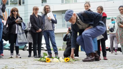 Teilnehmende der Stolpersteinverlegung legen Blumen nieder