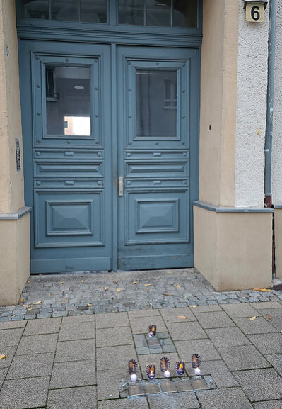 Geputzte und mit Lichtern versehene Stolpersteine für Familie Jungmann und Max Pinkus
