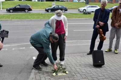 Sonia Ascher und ihr Mann legen Rosen an den Stolperstein nieder.