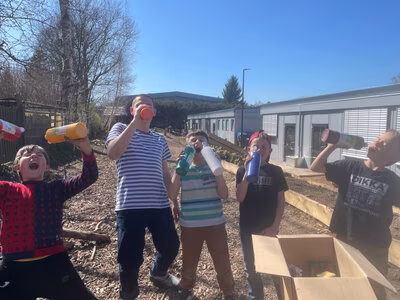 Kinder der gruuna Schule mit ihrem Lehrer bei einer Trinkpause