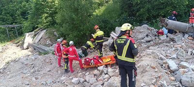 Zu sehen sind mehrere Einsatzkr&auml;fte auf einem Schuttberg.