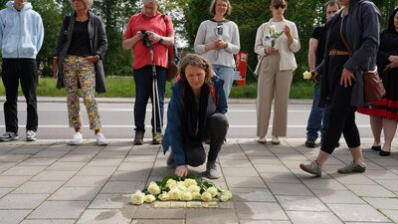Teilnehmende der Stolpersteinverlegung legen Rosen nieder