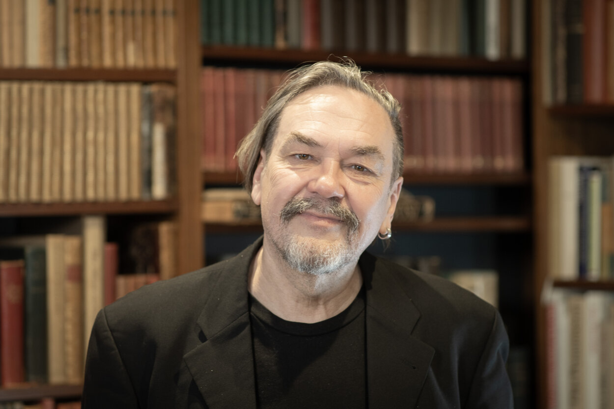 Schriftsteller Juri Andruchowytsch steht lächelnd vor einem Bücherregal im Stefan-Heym-Forum.