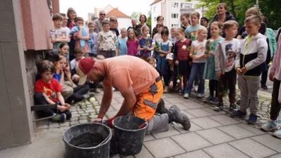Ein Mitarbeiter des Chemnitzer Bauhofes verlegt den Stolperstein für Familie Sommerfeld/ Kaes