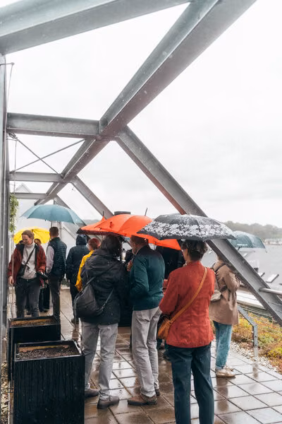 Dachgarten mit Stahlkonstruktion, darunter Besucher mit Regenschirmen in Chemnitz.