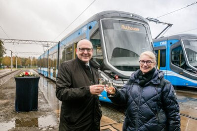 Oberbürgermeister Sven Schulze stößt mit Michèle Lutz auf die getaufte Straßenbahn an.