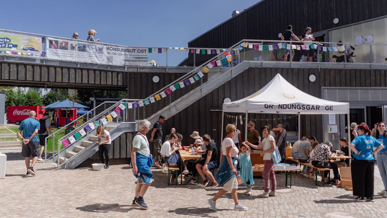 Hof der Stadtwirtschaft Chemnitz mit Treppenaufgang zum ersten Geschoss, Wimpelkette und vielen Menschen beim Hoffest 2025.