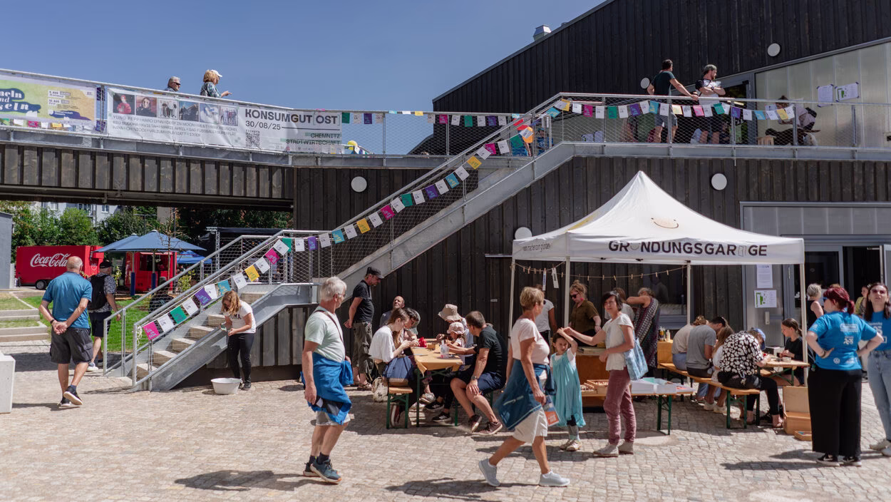 Hof der Stadtwirtschaft Chemnitz mit Treppenaufgang zum ersten Geschoss, Wimpelkette und vielen Menschen beim Hoffest 2025.