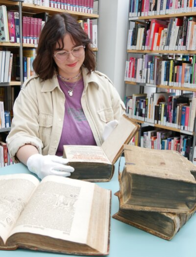 Bibliotheks-Auszubildende Luisa Kahnt betrachtet die wertvollen Exponate
