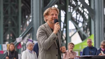 Baubürgermeister Michael Stötzer in Nahaufnahme während seiner Rede unter dem Eisenbahnviadukt.