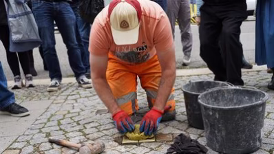 Ein Mitarbeiter des Chemnitz Bauhofes verlegt die Stolpersteine für Familie Goeritz