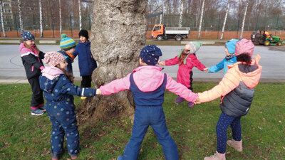 Kinder um einen Baum