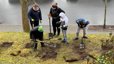 Kinder und Betreuende des Erich Kästner Förderzentrums Aue beim Pflanzen von Rosensträuchern