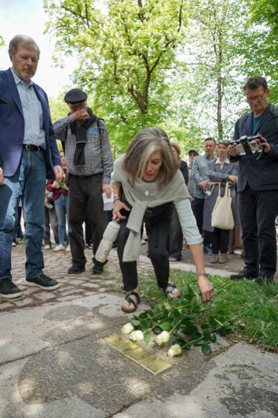 Angehörige legen Rosen an die Stolpersteine nieder.