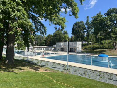 Der Schwimmbereich wurde von der Liegewiese aus fotografiert. Rechts ist das Mehrzweckbecken und links befindet sich das Schwimmbecken.