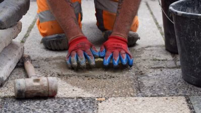 Ein Mitarbeiter des Chemnitzer Bauhofes verlegt die Stolpersteine für Familie Rappel