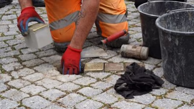 Ein Mitarbeiter des Chemnitz Bauhofes verlegt die Stolpersteine für Familie Goeritz