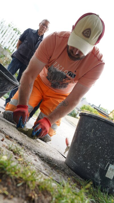 Ein Mitarbeiter des Chemnitzer Bauhofes verlegt den Stolperstein für Rudolf Dähnert