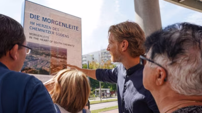 Bürgermeister Michael Stötzer erklärt mehreren Personen wichtige Fakten zur Informationsstele Morgenleite