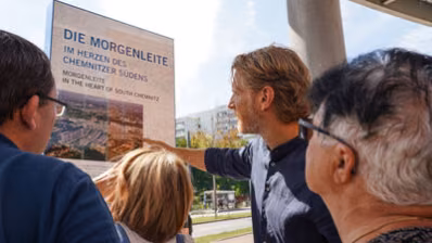 Bürgermeister Michael Stötzer erklärt mehreren Personen wichtige Fakten zur Informationsstele Morgenleite