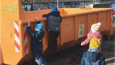 Kinder vor einem Müllcontainer