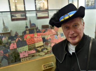 Stefan Weber im Türmerzimmer des Rathauses vor einer Miniaturansicht der Stadt Chemnitz
