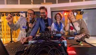 Mitarbeitende des smac – Staatliches Museum für Archäologie Chemnitz stehen während der Museumsnacht mit ihren eigenen Playlists am DJ-Pult.